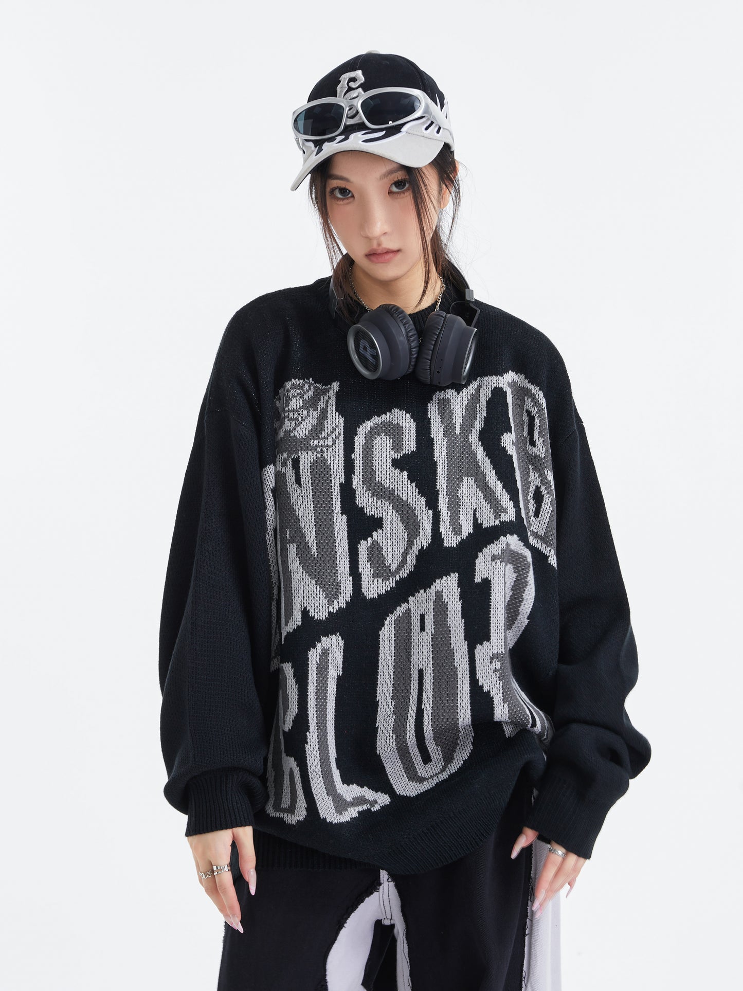 Black UNS Club sweater front model view with headphones