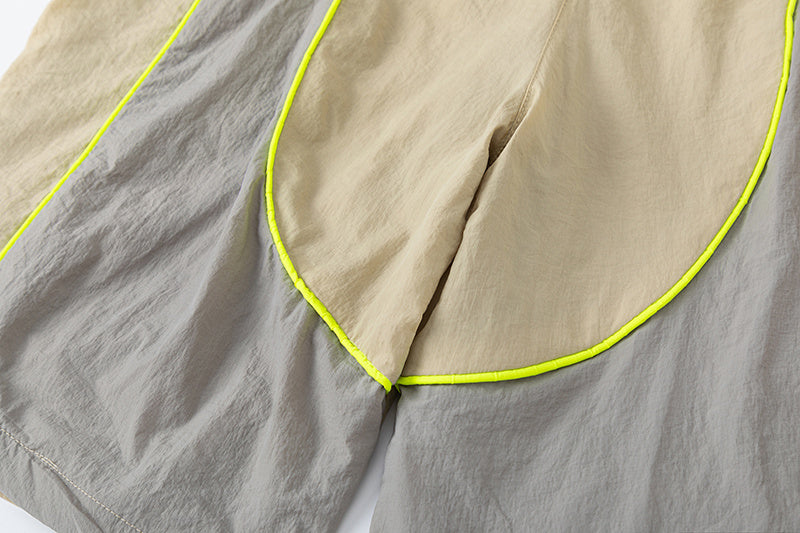 Blue and khaki drawstring casual shorts with elastic waist, side pockets, contrast piping, and small leg emblem - view 4