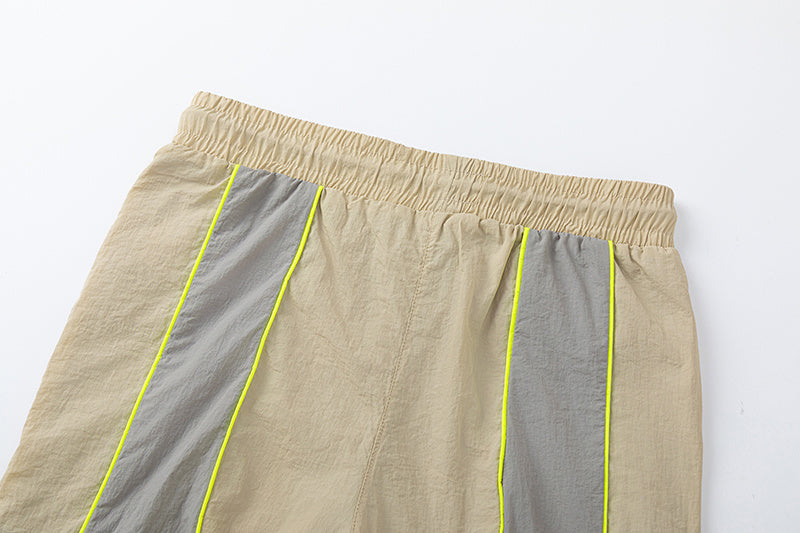 Blue and khaki drawstring casual shorts with elastic waist, side pockets, contrast piping, and small leg emblem - view 5