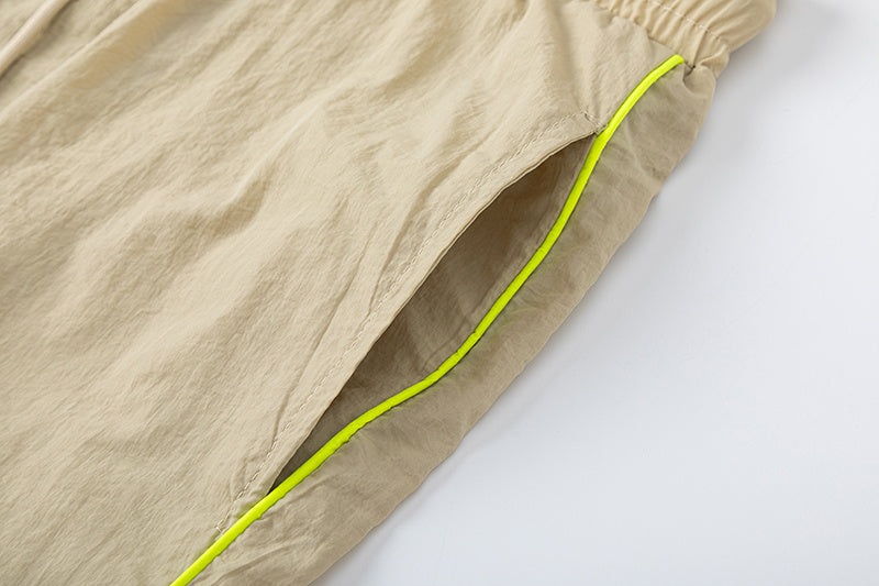 Blue and khaki drawstring casual shorts with elastic waist, side pockets, contrast piping, and small leg emblem - view 7