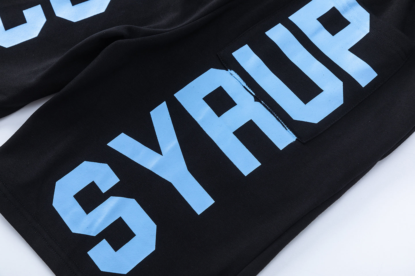 Men's black graphic shorts with light blue lettering, bottle-and-wings print, drawstring waist, and rear patch pock - view 10