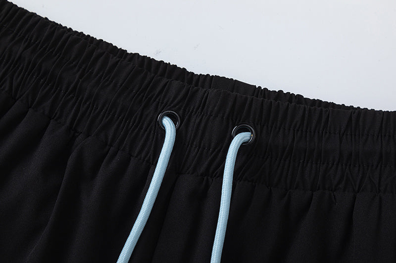 Black unisex drawstring shorts with blue letter graphic, elastic waistband, and side pockets - view 13