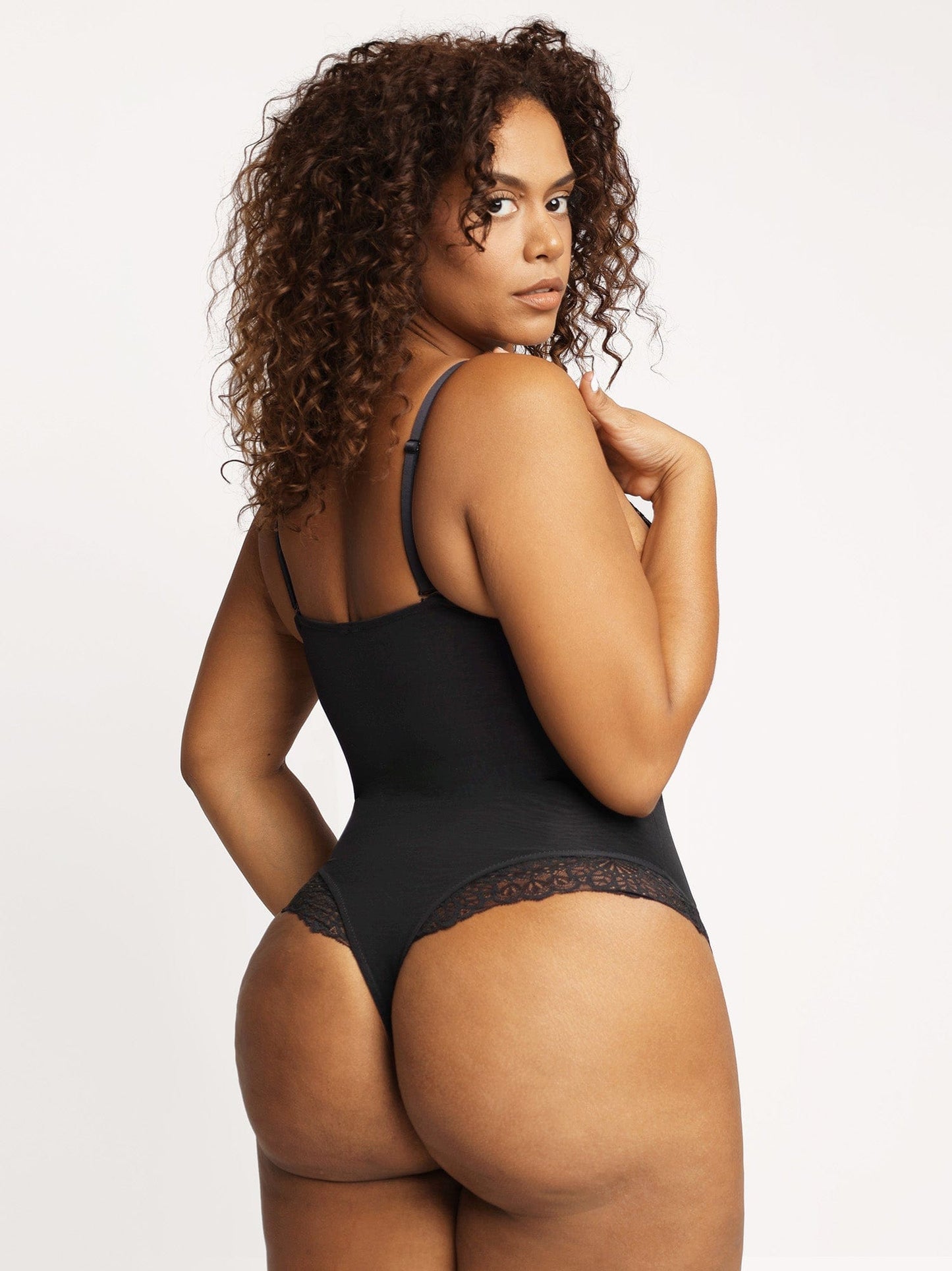 Woman in Popilush® black lace bodysuit, for comfort and style.